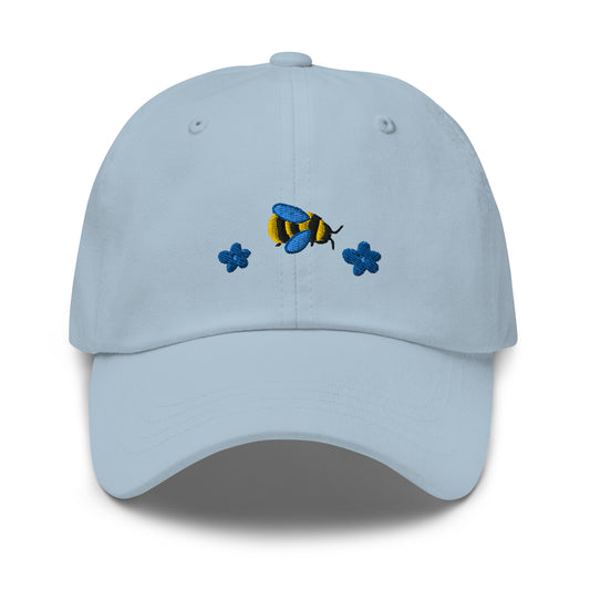 Light blue hat with embroidered cartoon and two embroidered dark blue flowers
